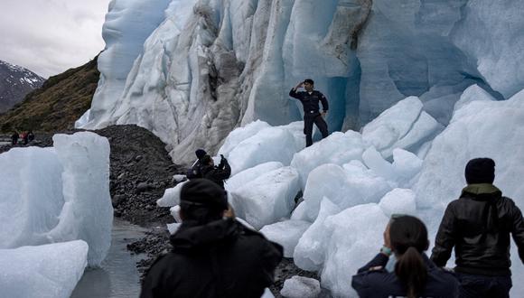 Tripulantes del buque de investigación científica de la Armada de Chile Cabo de Hornos toman fotografías en el glaciar Fouque, en la región de Magallanes, Chile, el 30 de noviembre de 2021. (Nicolas GARCIA / AFP)