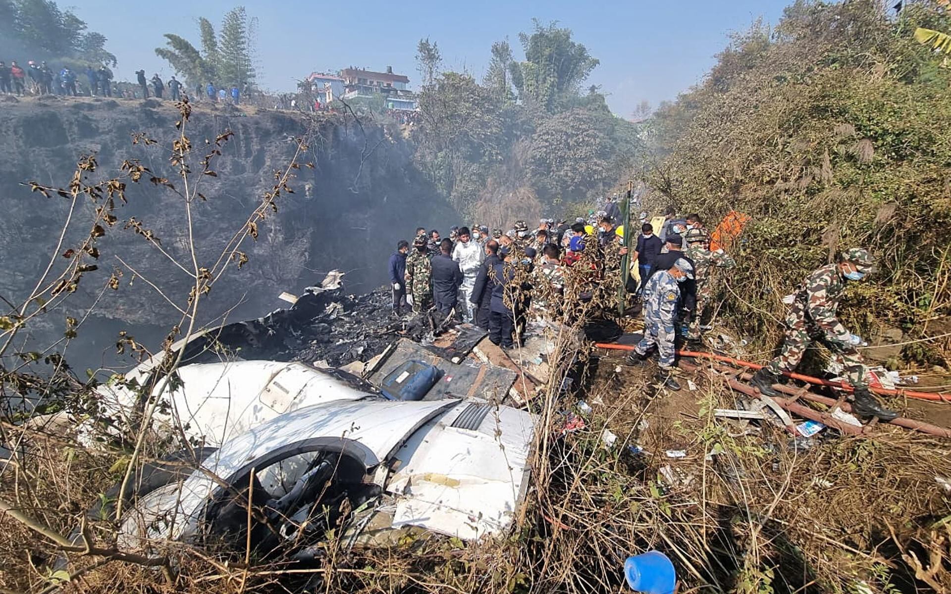 Rescue teams work on the wreckage of a Yeti Airlines ATR72 plane after it crashed in Pokhara, Nepal, on January 15, 2023. (EFE/EPA/BIJAYA NEUPANE).