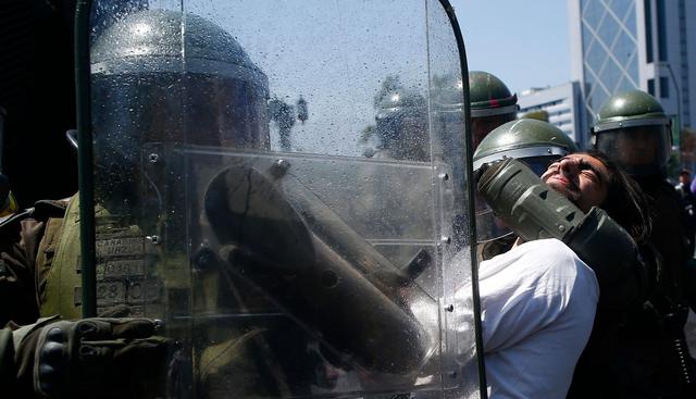 La policía detiene a un manifestante en el centro de Santiago. (AFP / Pablo VERA).
