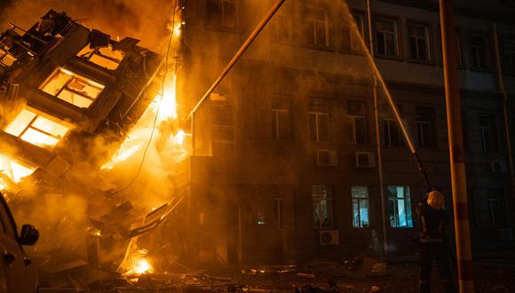 Los rescatistas extinguiendo un incendio en un edificio administrativo en Odesa como resultado de un ataque con misiles, en medio de la invasión rusa en Ucrania. (Foto de Handout / Servicio de emergencia de Ucrania / AFP)