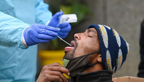 Un trabajador médico toma una muestra de un hisopo de un hombre para una prueba de coronavirus Covid-19 en un centro de salud en Nueva Delhi, India, el 4 de enero de 2022. (Prakash SINGH / AFP).