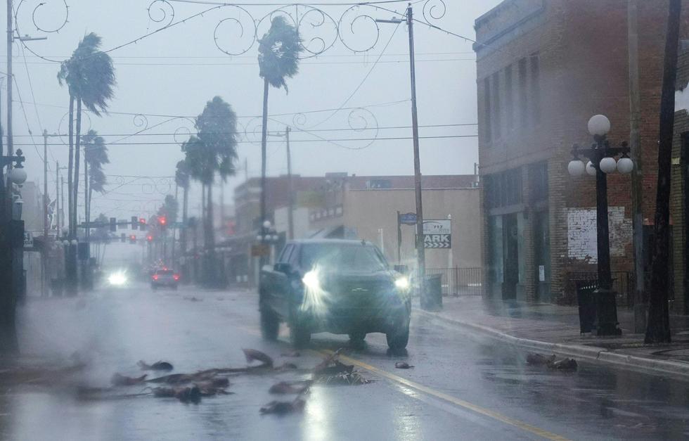 Una camioneta conduce entre escombros caídos y palmeras en el vecindario de Ybor City antes de que el huracán Ian toque tierra el 28 de septiembre de 2022 en Tampa, Florida. (Bryan R. Smith / AFP)