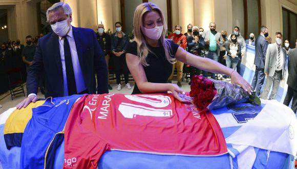 En esta fotografía divulgada por la Presidencia de Argentina, el presidente Alberto Fernández y la primera dama Fabiola Yáñez tocan el féretro que contiene los restos de Diego Maradona. (Presidencia de Argentina/AP).