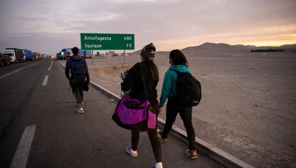Los migrantes venezolanos Reinaldo (izquierda), de 26 años, Anyier (centro), de 40, y su hija Danyierly, de 14, caminan por la carretera rumbo a Iquique, luego de cruzar desde Bolivia, en Colchane, Chile, el 18 de febrero de 2021. (FOTO REFERENCIAL, MARTIN BERNETTI / AFP).