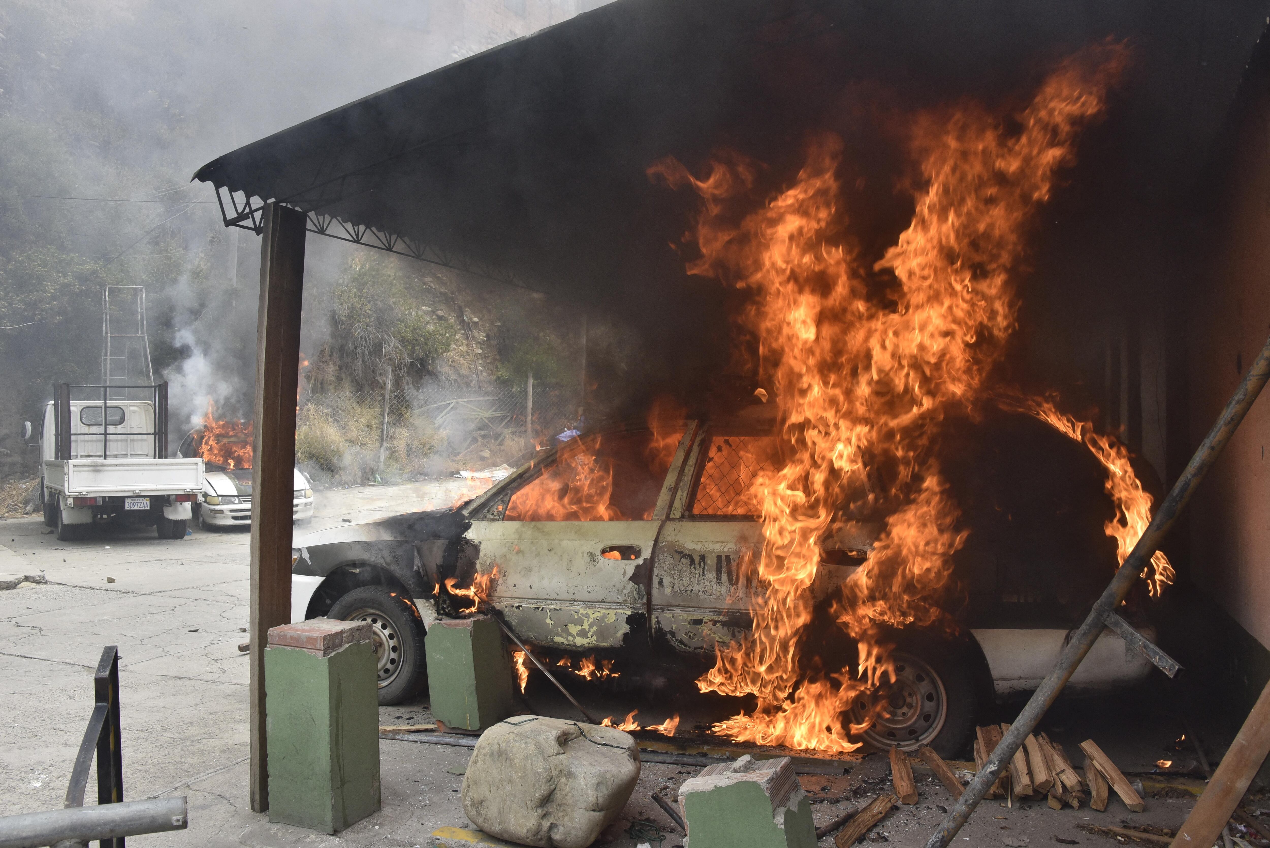 Vista de un auto policial incendiado en una comisaría agredido por un grupo de productores de hoja de coca en el marco de los enfrentamientos que intentaban tomar el Mercado de Coca en La Paz. (Foto: AIZAR RALDES / AFP)