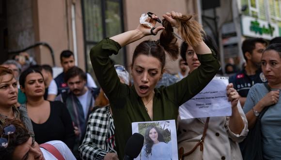 Nasibe Samsaei, una mujer iraní que vive en Turquía, se corta la cola de caballo durante una protesta frente al consulado iraní en Estambul el 21 de septiembre de 2022, luego de la muerte de una mujer iraní luego de su arresto por parte de la policía de moralidad del país en Teherán. (Foto: Yasin AKGUL / AFP)