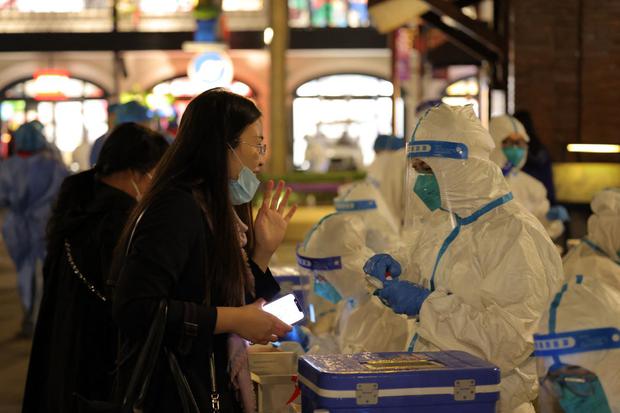 Personal médico examina a los visitantes para detectar el coronavirus en Disneyland en Shanghái. (AFP).