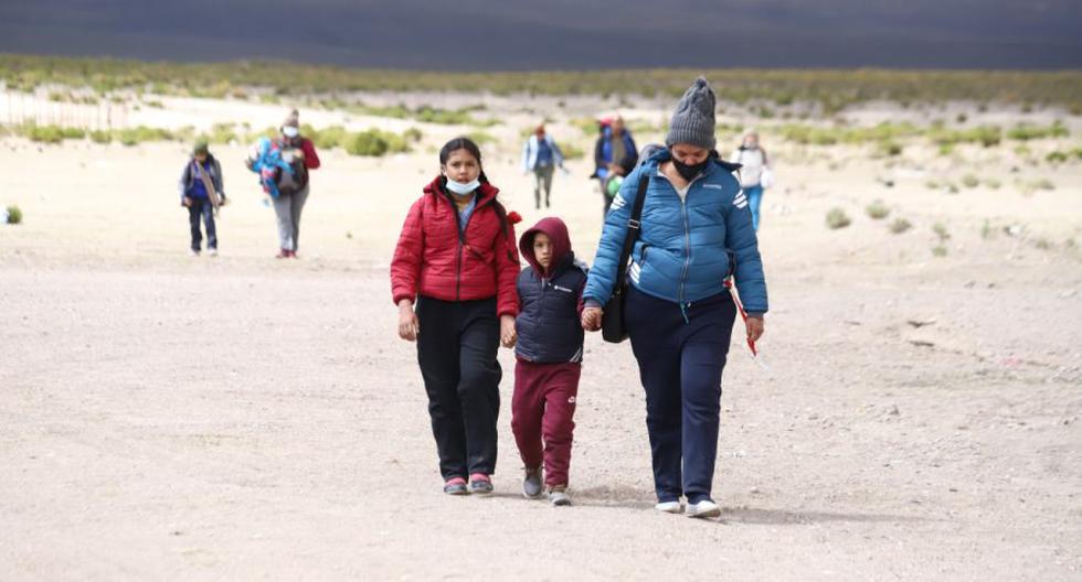 Una mujer venezolana y sus hijos caminan por el desierto después de cruzar ilegalmente por la frontera entre Bolivia y Chile en Colchane. La imagen es del 3 de febrero. (Foto: IGNACIO MUNOZ / AFP)