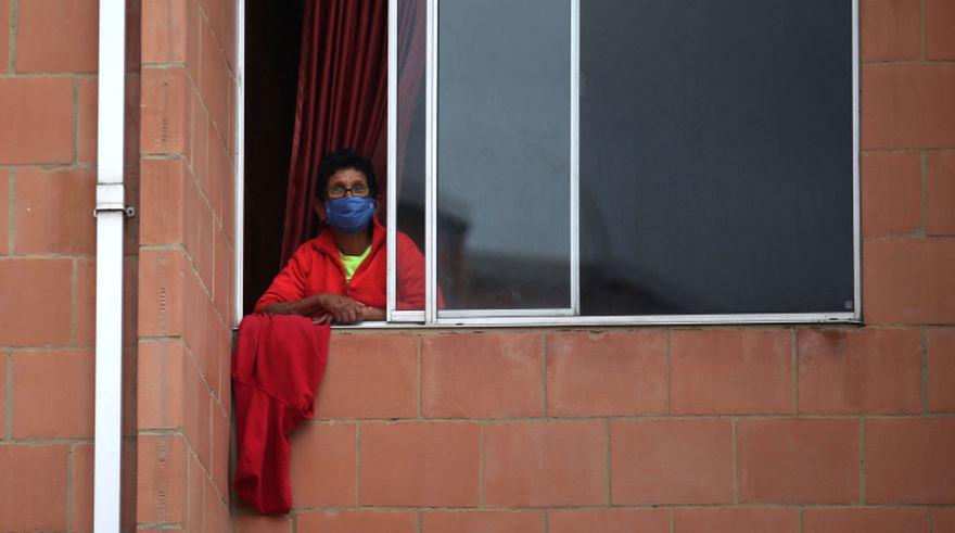 Una mujer cuelga un trapo rojo en una ventana como señal para recibir ayuda y subsidios del gobierno de Colombia. (Foto: REUTERS / Luisa Gonzalez).