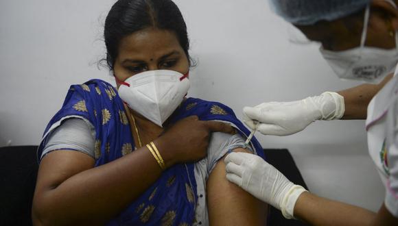 Personal sanitario inocula a una mujer con la vacuna contra el coronavirus de Covaxin en un hospital de la India. (Foto de Arun SANKAR / AFP).