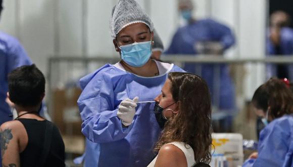 Un trabajador de la salud toma muestras de una mujer para detectar la enfermedad del nuevo coronavirus COVID-19 en un centro de pruebas gratuito en Buenos Aires. (Foto: ALEJANDRO PAGNI / AFP)