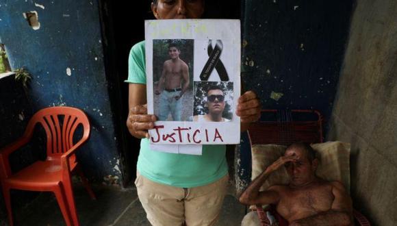 Foto de archivo de Judith Cortez sosteniendo imágenes de sus hijos Jose Alfredo y Anderson Torres. (REUTERS/Ivan Alvarado).