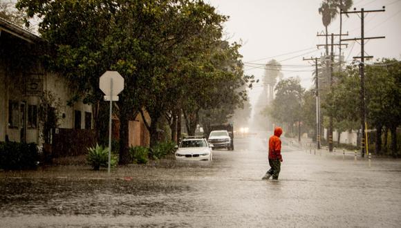 Un hombre cruza una calle inundada durante una tormenta en Santa Bárbara, California, el 4 de febrero de 2024. (EFE/EPA/ERICK MADRID).