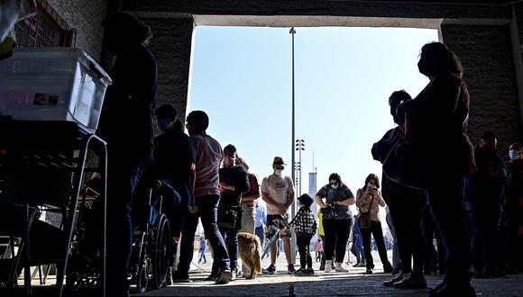La gente hace fila para emitir su voto durante un referéndum para aprobar o rechazar una nueva Constitución en un colegio electoral en Santiago, el 4 de septiembre de 2022. (Foto de MARTIN BERNETTI / AFP)
