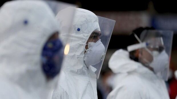 Trabajadores usan trajes protectores para limpiar en Corabastos, uno de los centros de distribución de alimentos más grandes de América Latina, en un esfuerzo por contener la propagación del nuevo coronavirus en Bogotá (Foto: AP / Fernando Vergara)