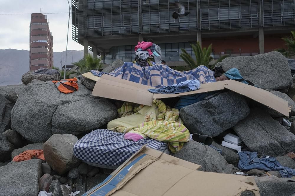 Venezuelan migrants sleep on rocks along the seashore in El Morro, a neighborhood of Iquique, Chile.  (AP Photo / Matias Delacroix)