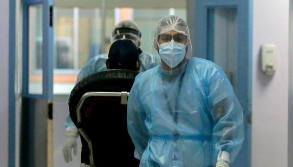 Los paramédicos Jasser Patiño y José Villaverde ingresan a un hombre de 44 años con problemas respiratorios en un hospital de la Ciudad de Panamá. (Foto: AFP)