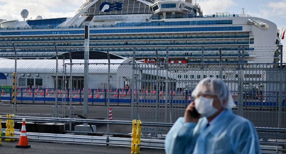 Un hombre con equipo de protección habla por teléfono cerca del crucero Diamond Princess en cuarentena debido al temor de la propagación del nuevo coronavirus COVID-19. (AFP)