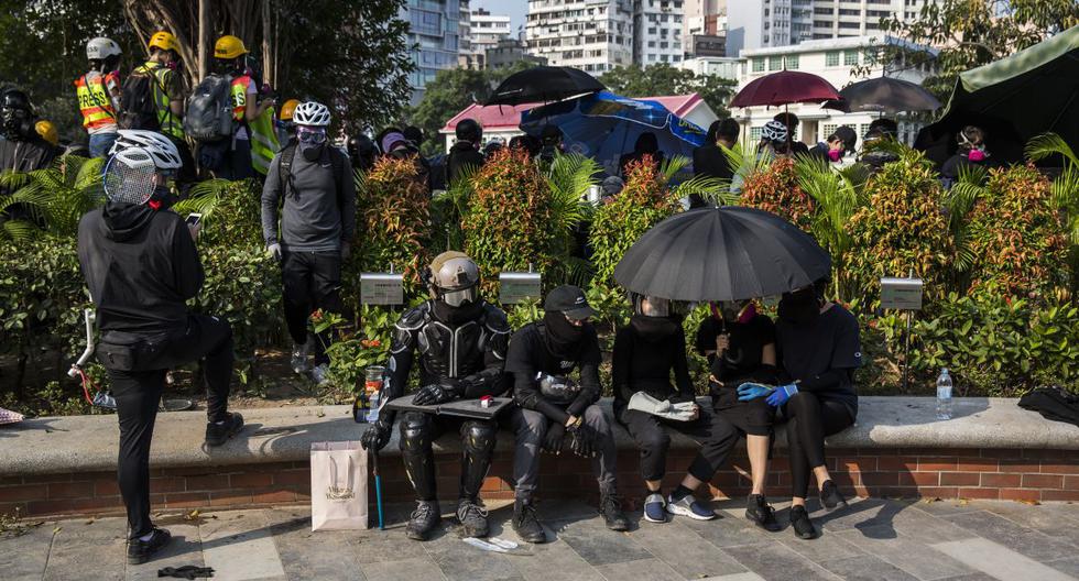 Un grupo de manifestantes se sienta dentro del campus de la Universidad Politécnica de Hong Kong mientras la policía (que no se aprecia en la imagen) espera afuera del centro de estudios. (AFP)