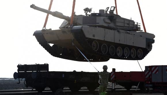 Un soldado estadounidense ayuda a maniobrar un tanque Abrams desde un vagón de tren mientras el personal del ejército estadounidense descarga equipo militar en la base aérea Mihail Kogalniceanu cerca de Constanta en Rumania. (Foto: DANIEL MIHAILESCU / AFP)