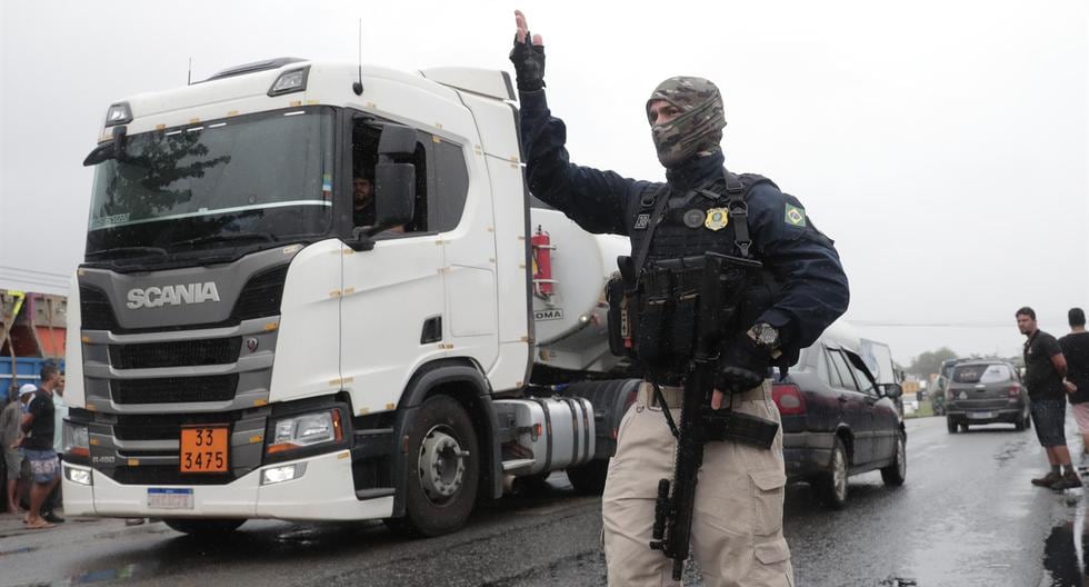 Miembros de la policía custodian a grupos de camioneros que bloquean carreteras en Río de Janeiro, Brasil. (EFE/ André Coelho).