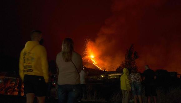 La gente observa el volcán Cumbre Vieja arrojando lava, ceniza y humo desde El Paso, en la isla canaria de La Palma, a última hora del 2 de octubre de 2021. (Foto: JORGE GUERRERO / AFP).