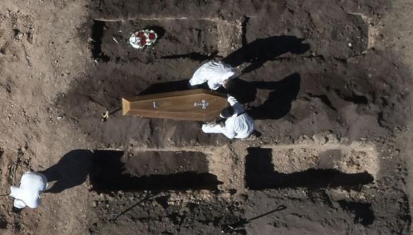 Vista aérea de trabajadores enterrando un ataúd en un área despejada para acomodar nuevas fosas para debido al coronavirus COVID-19 en el cementerio de Chacarita en Buenos Aires, Argentina. (Foto de Emiliano Lasalvia / AFP).