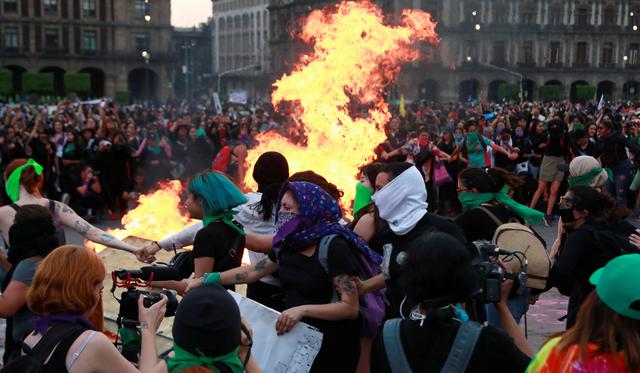 Las mujeres corren alrededor del guego en el Zócalo durante una marcha por el Día Internacional de la Mujer en la Ciudad de México. (REUTERS / Henry Romero).