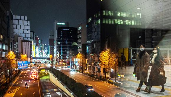 Una pareja camina en la estación Shimbashi de Tokio, bajo las nuevas restricciones del coronavirus covid-19 en varias regiones de Japón. (Philip FONG / AFP).