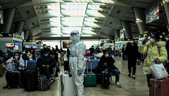 Un pasajero con equipo de protección en una estación de tren en Beijing el 28 de diciembre de 2022. (Foto referencial de Noel CELIS / AFP)