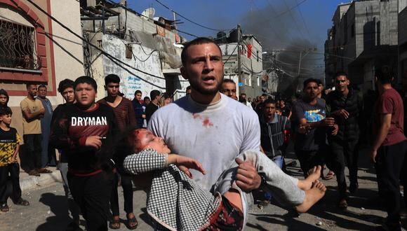 Un hombre evacua a una niña herida después del bombardeo israelí en Rafah, en el sur de la Franja de Gaza, el 17 de noviembre de 2023, en medio de batallas en curso entre Israel y el grupo palestino Hamás. (Foto de SAID KHATIB / AFP)