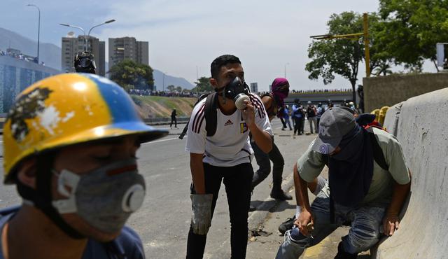 La Guardia Nacional arrojó gases lacrimógenos contra cientos de personas que intentaban bloquear una autopista en proximidades de la base aérea La Carlota, donde un grupo de militares se sublevó contra Nicolás Maduro. (AFP).
