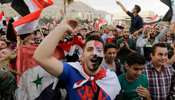 Cientos de sirios celebran desde la plaza ___, en Damasco, el empate de su selección con Australia. (AFP)