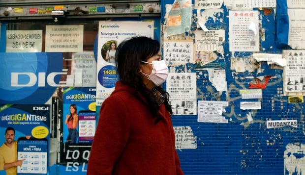 Una mujer utiliza una máscara protectora durante la epidemia del coronavirus mientras transita en una calle de Madrid, España. (Foto: AFP)
