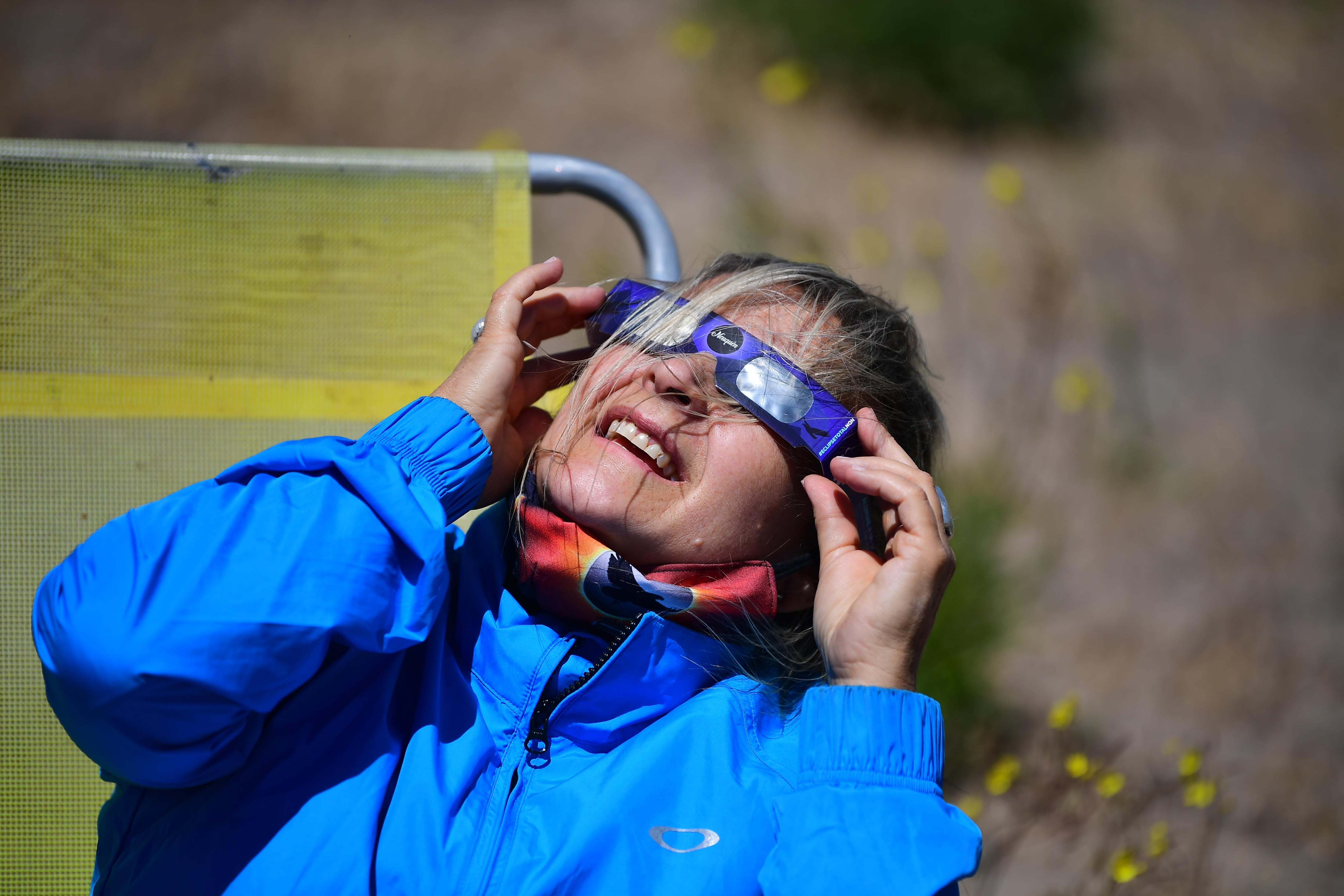 Una mujer observa el eclipse desde la región de Piedra del Aguila, en la provincia argentina de Neuquen, el 14 de diciembre de 2020.  RONALDO SCHEMIDT / AFP)