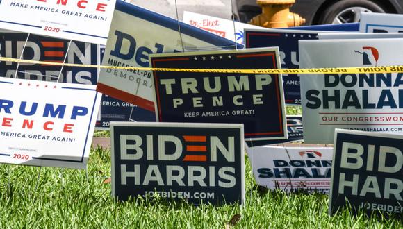 Los letreros de Trump-Pence y Biden-Harris se exhiben fuera de la biblioteca de Coral Gables en Miami, Florida, el 27 de octubre de 2020. (Foto de CHANDAN KHANNA / AFP).