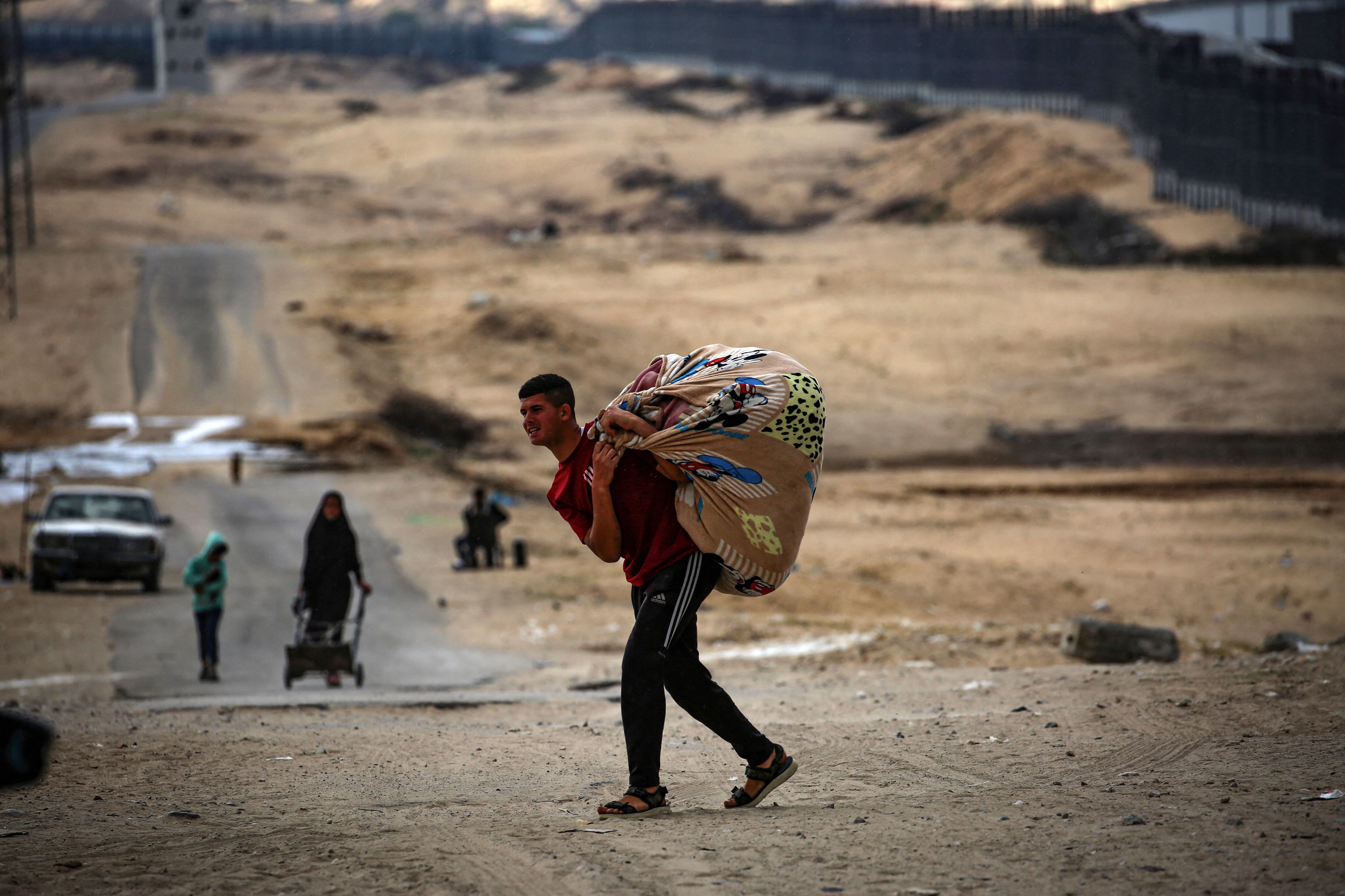 Los palestinos cargan sus pertenencias mientras se preparan para huir de Rafah, en el sur de la Franja de Gaza, el 13 de mayo de 2024. (Foto de AFP).