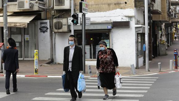 Unas personas pasean con mascarillas por la ciudad israelí de Bnei Brak, cerca de Tel Aviv, el pasado mes de abril. (Foto: Menahem Kahana/AFP).