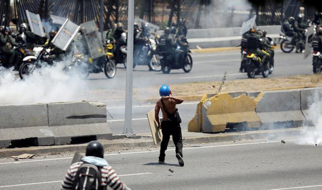 La Guardia Nacional arrojó gases lacrimógenos contra cientos de personas que intentaban bloquear una autopista en proximidades de la base aérea La Carlota, donde un grupo de militares se sublevó contra Nicolás Maduro. (Reuters).