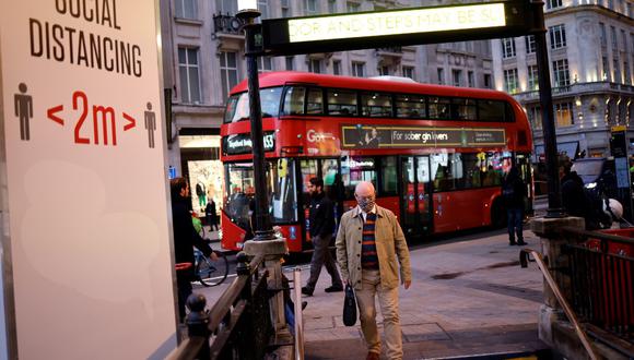 Un hombre utiliza una cubierta facial como medida de precaución contra el COVID-19, camina hacia la estación de metro de Oxford Circus, en el centro de Londres. (Tolga Akmen / AFP)