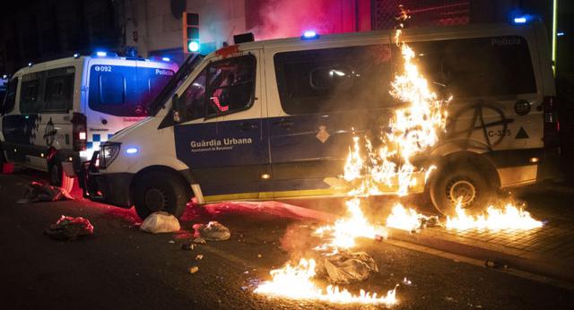 Una camioneta de la policía es incendiada mientras los manifestantes arrojan cócteles molotov a la policía durante los enfrentamientos luego de una protesta que condena el arresto del cantante de rap Pablo Hasél en Barcelona, ​​España. (Foto: AP / Emilio Morenatti)