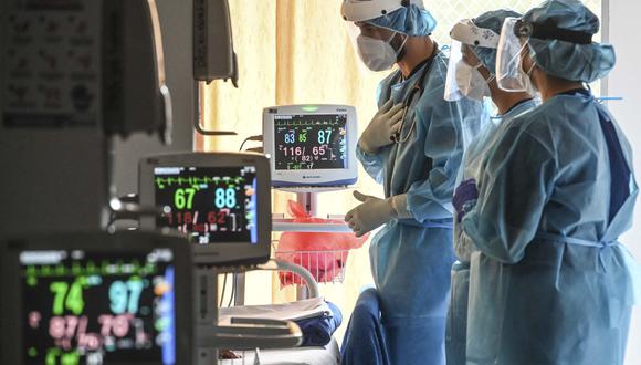 Trabajadores de salud revisan a un paciente con COVID-19 en la unidad de cuidados respiratorios no invasivos de una Clínica EPS SURA en Medellín, Colombia, el 2 de febrero de 2021. (Joaquín SARMIENTO / AFP).