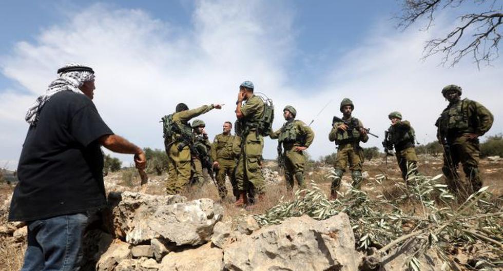 Granjeros palestinos discuten con soldados israelíes que les han cortado el paso de camino a un campo de olivos para realizar la cosecha. (Foto referencial: EFE)
