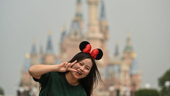 Una mujer hace un gesto mientras visita el parque de diversiones Disneyland en Shanghái, China, el 11 de mayo de 2020. (Héctor RETAMAL / AFP).