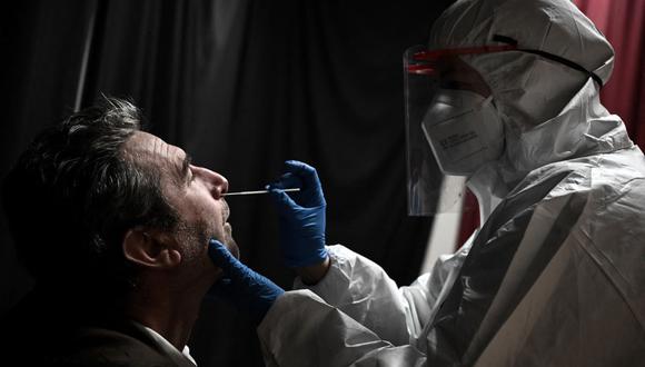 Un trabajador de la salud toma una muestra de hisopado nasal de un maestro para una prueba antigénica de coronavirus covid-19 en La Rochelle, suroeste de Francia, el 13 de enero de 2022. (Philippe LOPEZ / AFP).