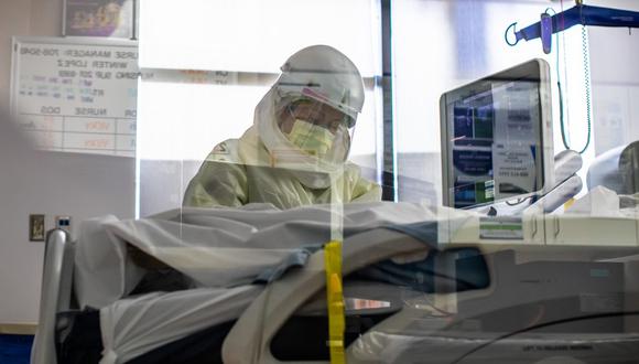 Una enfermera con equipo de protección personal (PPE) atiende a un paciente con COVID-19 en la Unidad de Cuidados Intensivos (UCI) en el Centro Médico Providence Cedars-Sinai Tarzana en California, el 18 de diciembre de 2020. (Apu GOMES / AFP).