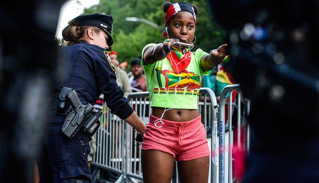 NEW YORK, NY - SEPTEMBER 4: Revelers are searched by police officers during a Caribbean street carnival called J'ouvert on September 4, 2017 in New York City. J'ouvert, which draws tens of thousands of costumed celebrants, has been plagued by violence in recent years resulting in new intensive security measures.  Stephanie Keith/Getty Images/AFP
== FOR NEWSPAPERS, INTERNET, TELCOS & TELEVISION USE ONLY ==