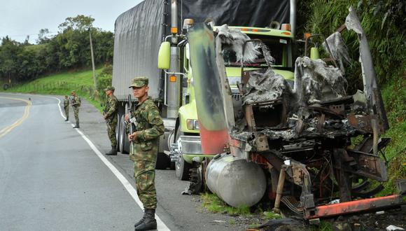 Los soldados montan guardia junto a un camión quemado por miembros del cártel de la droga Clan del Golfo, en una carretera cerca de Yarumal, departamento de Antioquia, Colombia, el 6 de mayo de 2022. ( JOAQUÍN SARMIENTO / AFP).