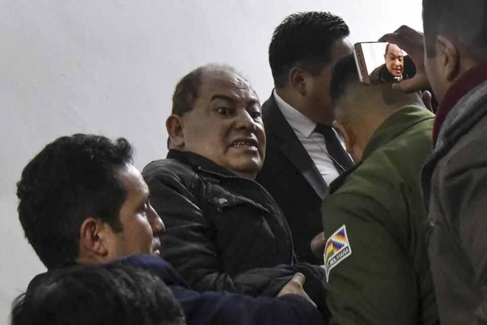 Carlos Romero al momento de su captura el martes, tras abandonar un centro médico de La Paz, como parte de una orden en su contra por no presentarse a declarar en una audiencia donde enfrenta acusaciones por corrupción. (AFP)