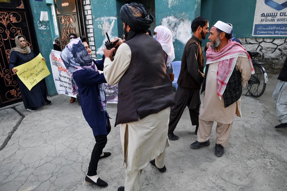 A protester argues with a member of the Taliban during a protest outside a school in Kabul on September 30, 2021. (BULENT KILIC / AFP).